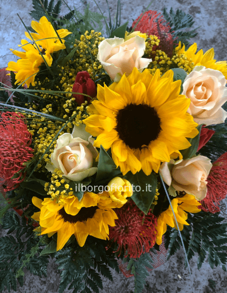 Composizione di fiori freschi assortiti, in particolare girasoli e rose.